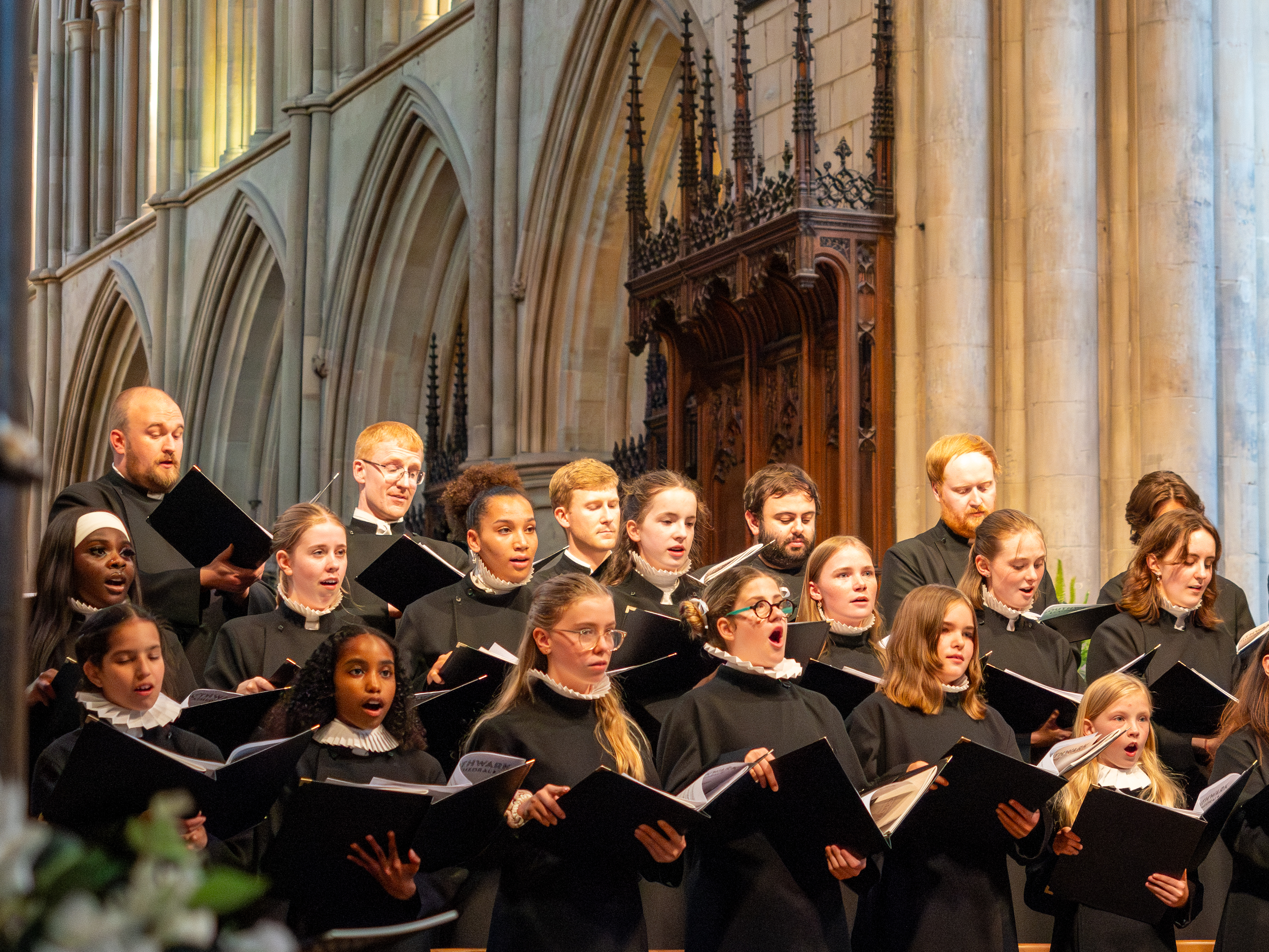 A choir wearing black singing in a cathedral